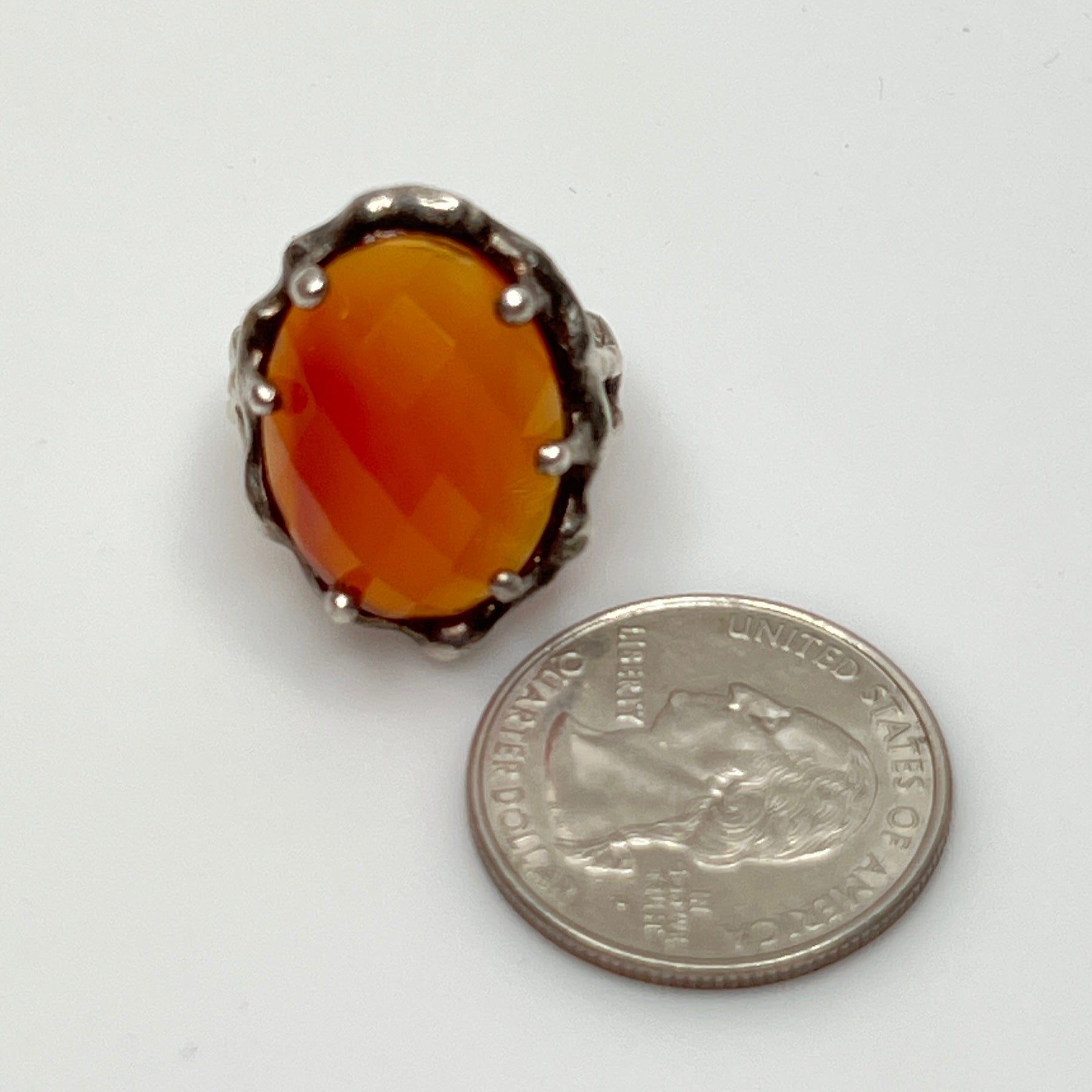 Vintage sterling silver ring with faceted oval orange carnelian in sculptural bezel setting