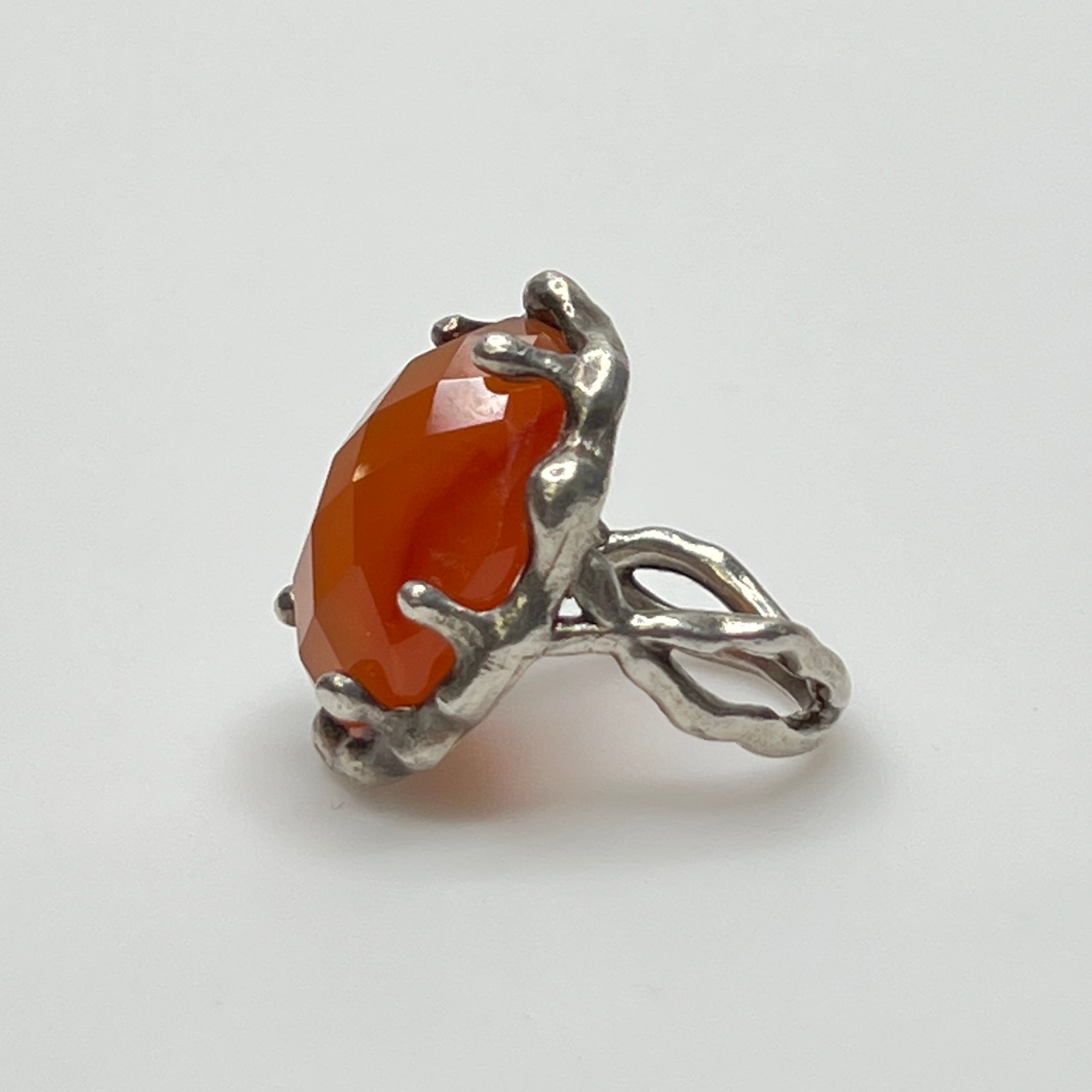 Vintage sterling silver ring with faceted oval orange carnelian in sculptural bezel setting