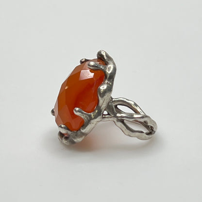 Vintage sterling silver ring with faceted oval orange carnelian in sculptural bezel setting