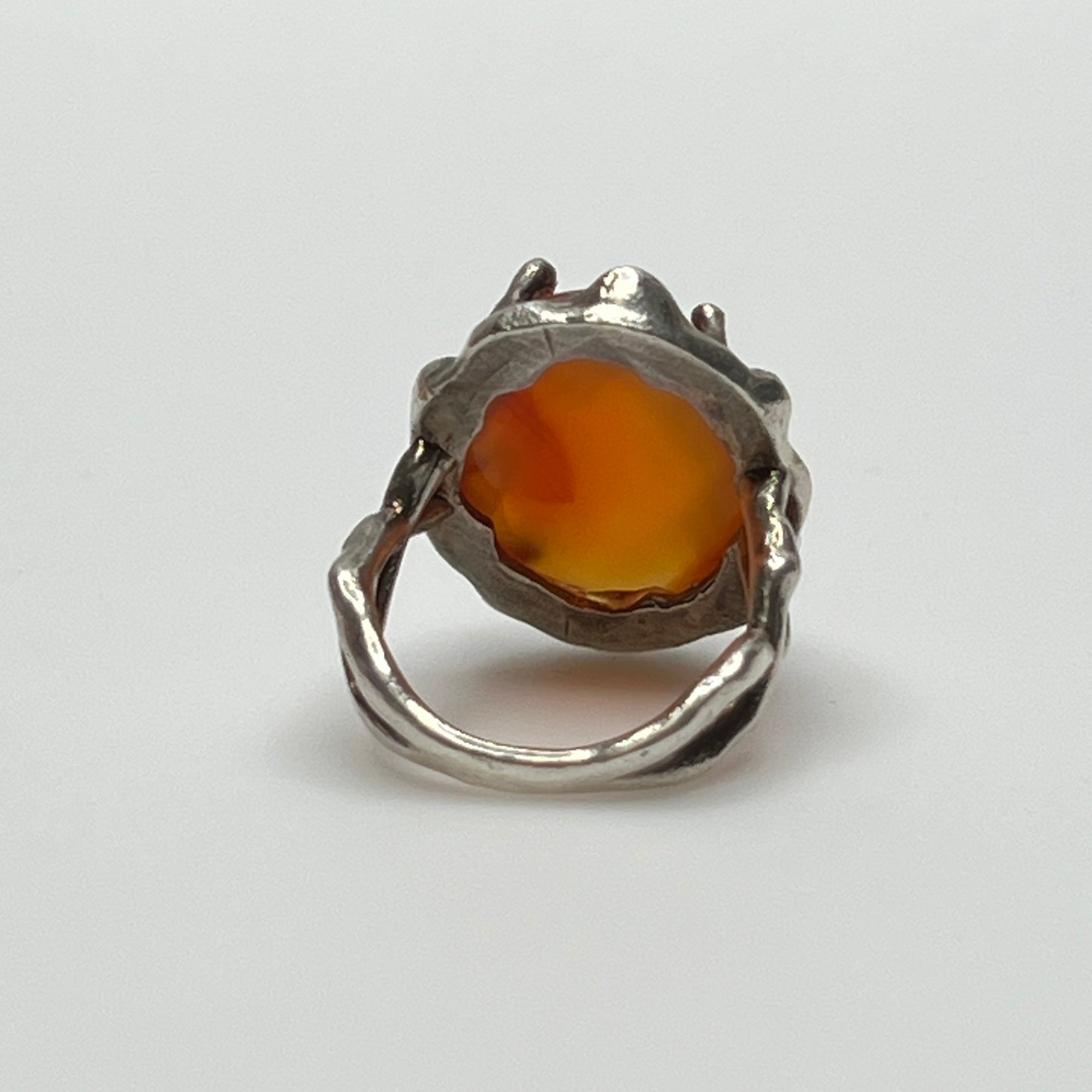 Vintage sterling silver ring with faceted oval orange carnelian in sculptural bezel setting