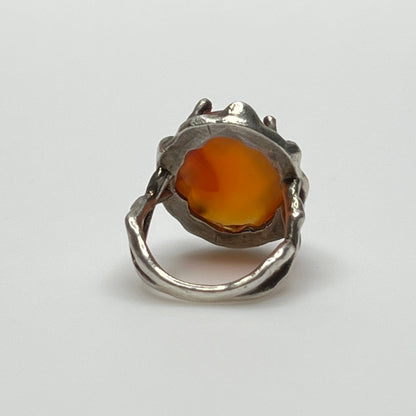 Vintage sterling silver ring with faceted oval orange carnelian in sculptural bezel setting