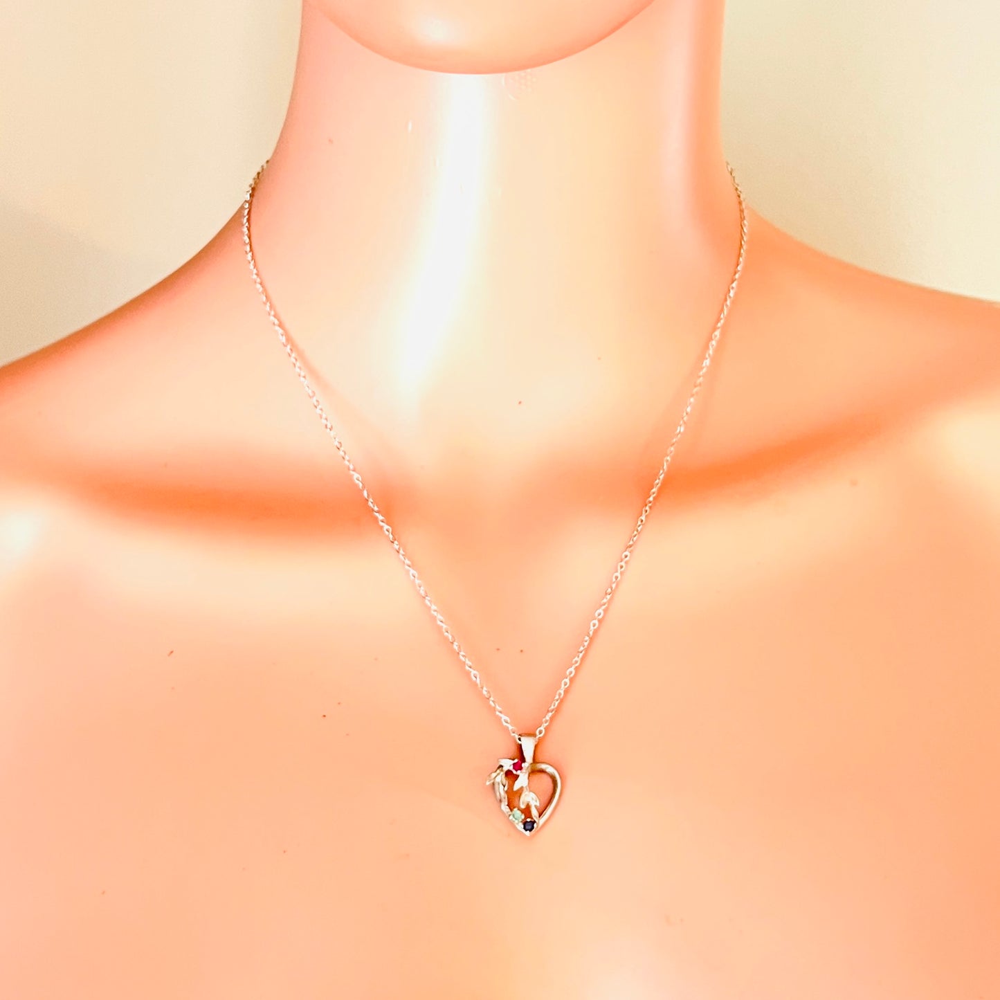 Avon sterling gemstone heart necklace displayed on mannequin showing 18-inch chain length.