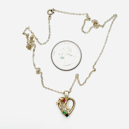 Vintage sterling silver heart pendant necklace beside quarter showing size and gemstone details.