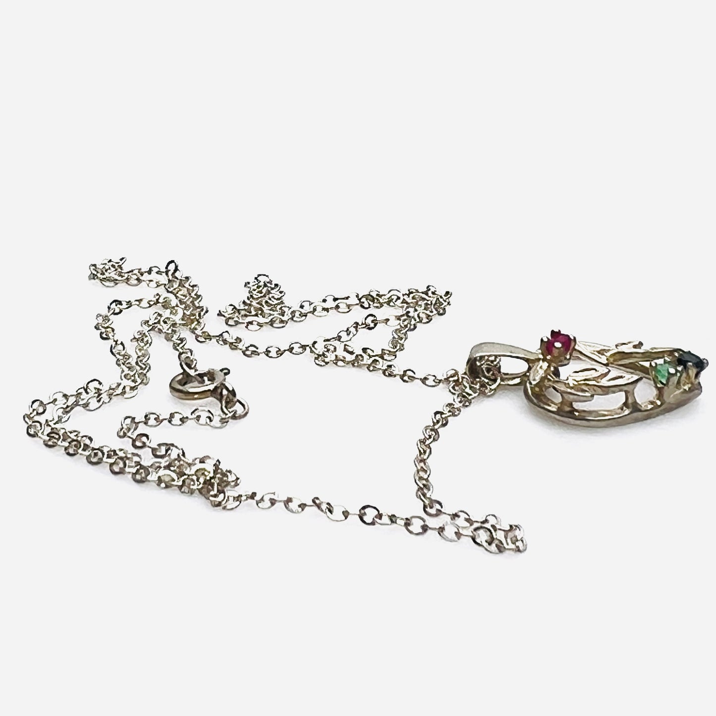 Side view of Avon sterling heart necklace with genuine ruby, emerald, and sapphire accents.