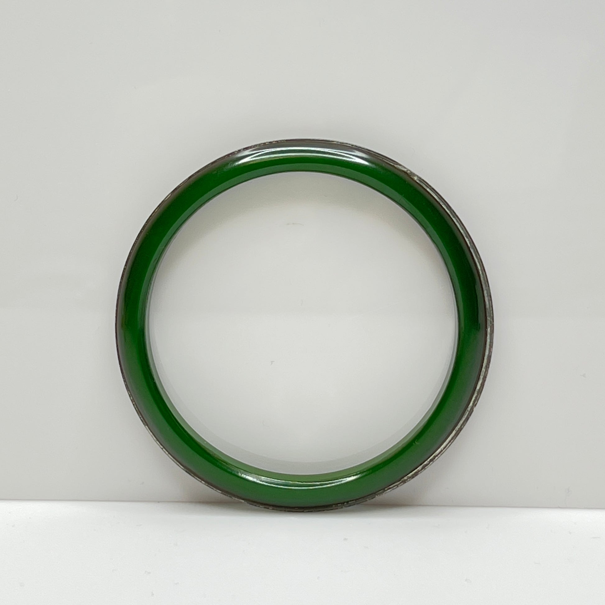 Deep green Bakelite bangle bracelet with metal insert, side view