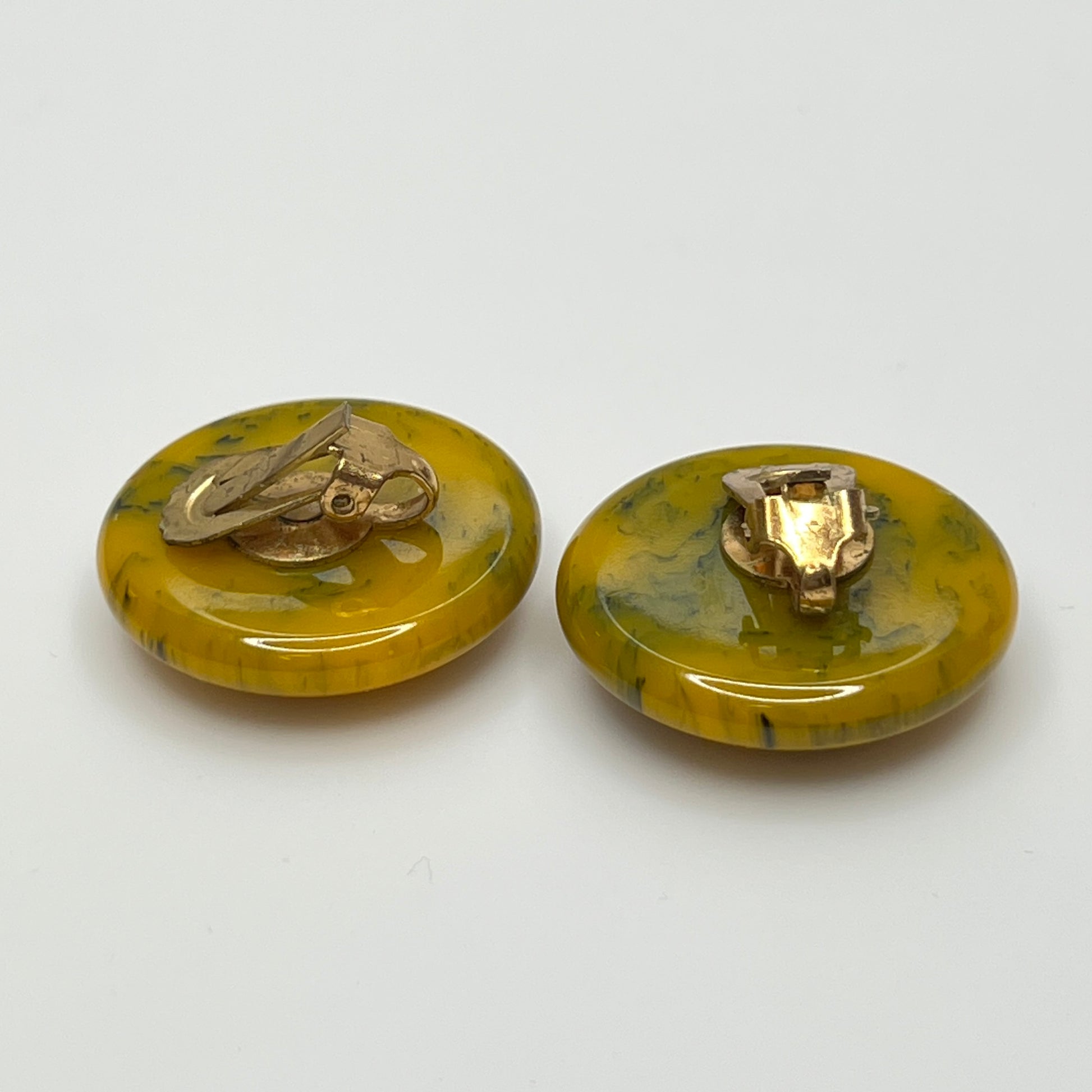 Pair of round marbled yellow and black Bakelite clip-on earrings