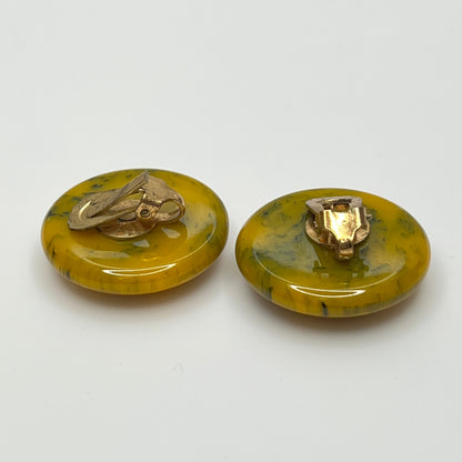 Pair of round marbled yellow and black Bakelite clip-on earrings