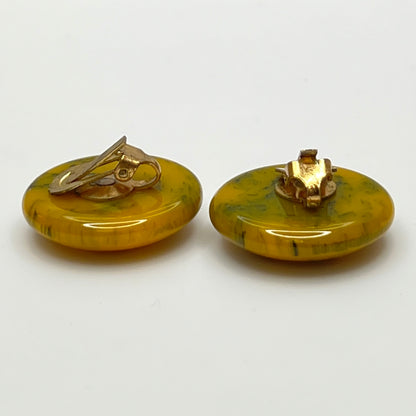 Pair of round marbled yellow and black Bakelite clip-on earrings
