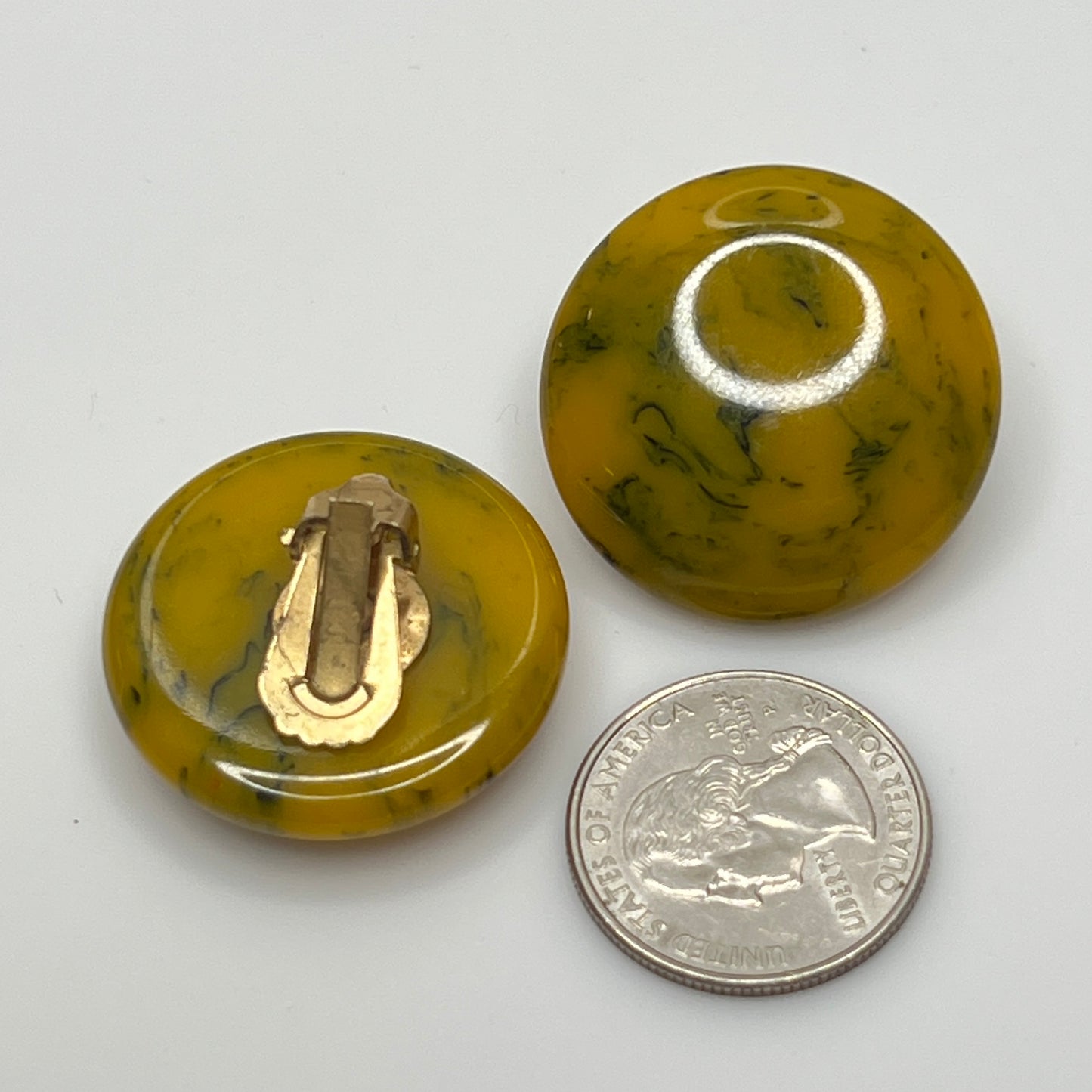 Pair of round marbled yellow and black Bakelite clip-on earrings