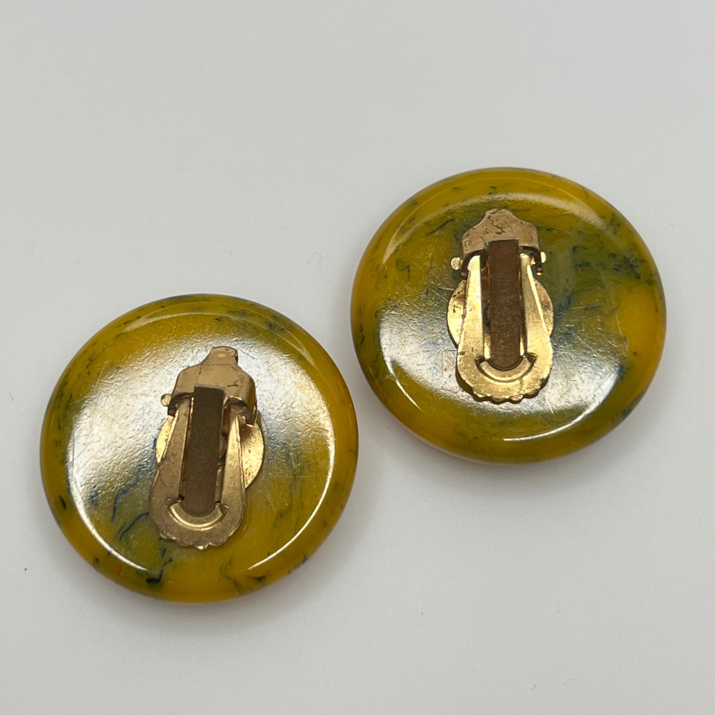 Pair of round marbled yellow and black Bakelite clip-on earrings