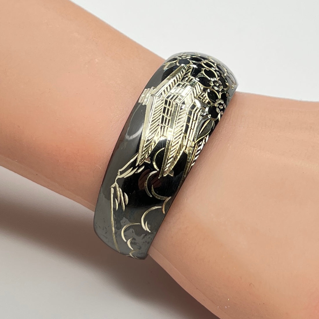 Bracelet shown on wrist, highlighting engraved silver pagoda and blossoms