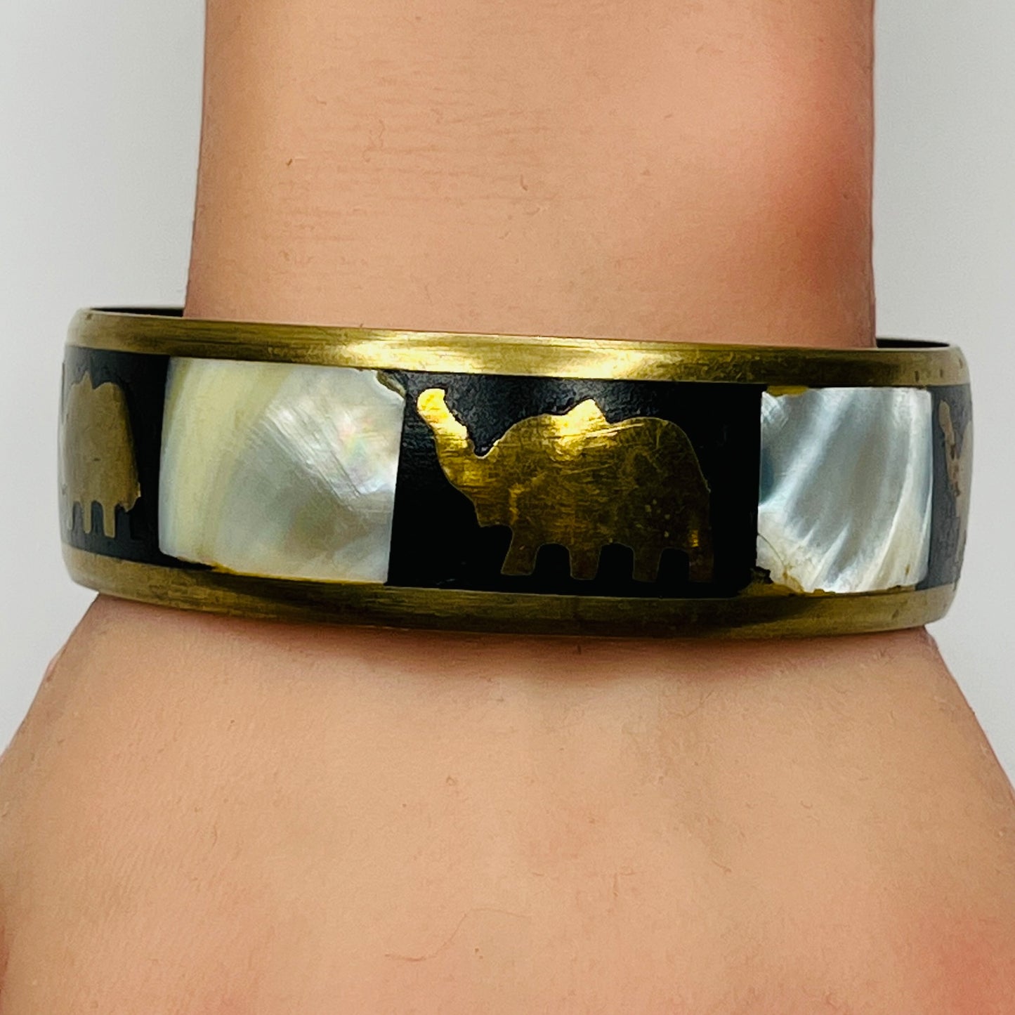 Brass elephant bangle worn on wrist, showcasing size and shine