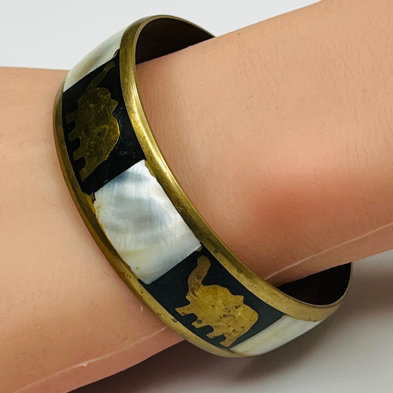 Brass elephant bangle worn on wrist, showcasing size and shine
