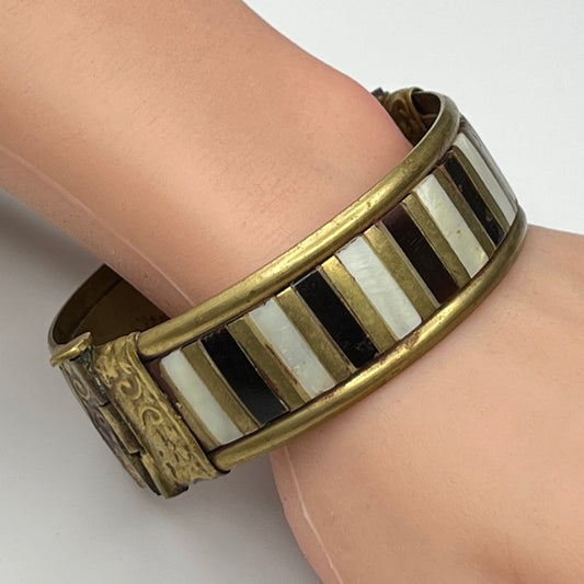 Rustic brass and mother of pearl artisan bangle worn on mannequin