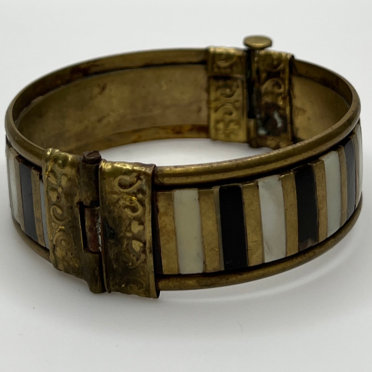 Vintage bangle with pin closure and etched end caps, close-up view