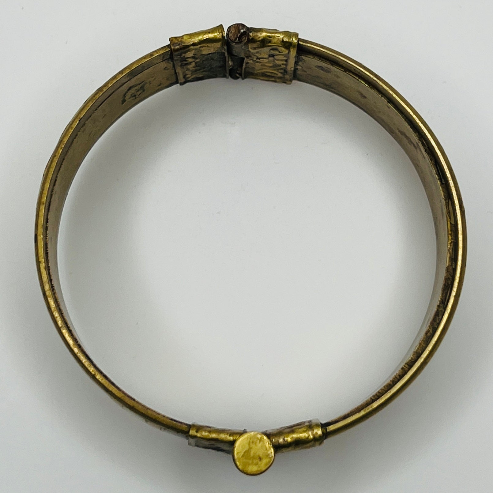 Vintage bangle with pin closure and etched end caps, close-up view