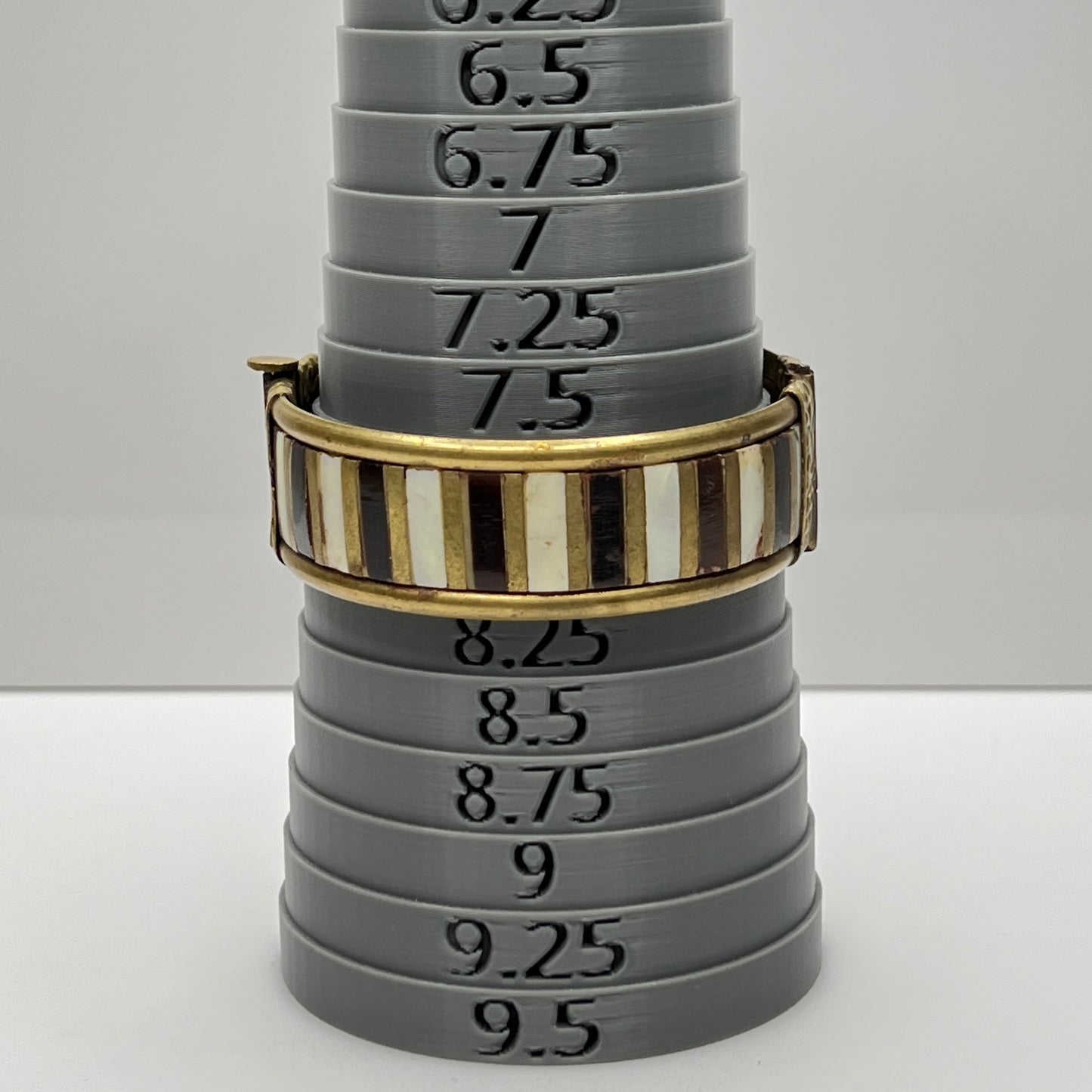 Vintage bangle with pin closure and etched end caps, close-up view