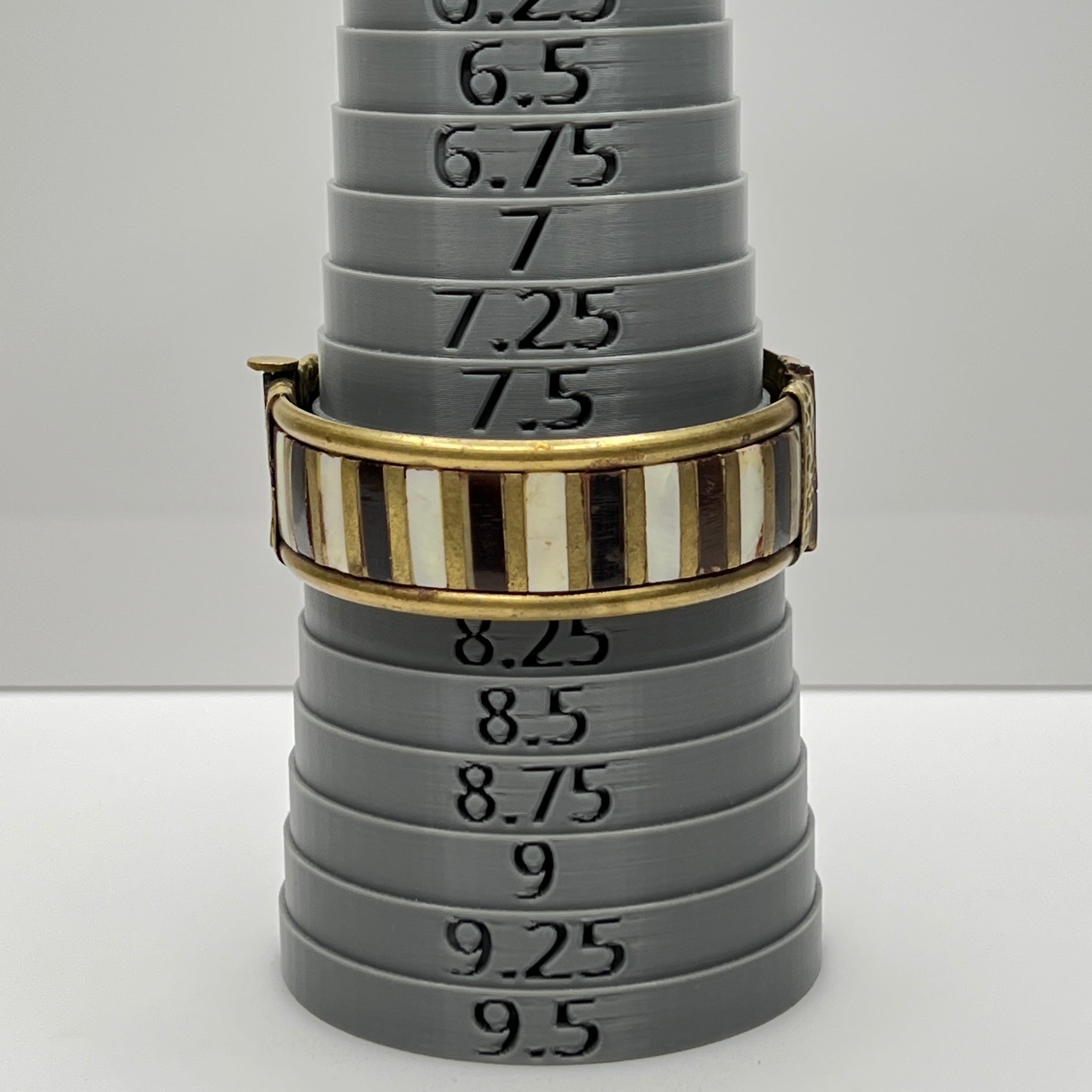 Vintage bangle with pin closure and etched end caps, close-up view