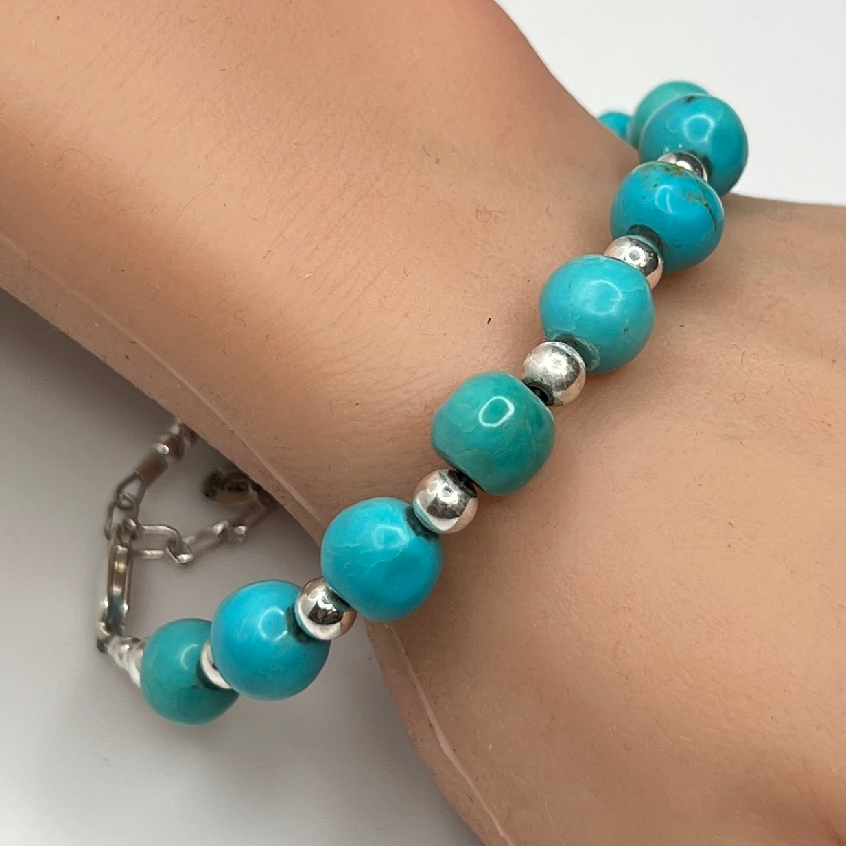 Turquoise and silver beaded bracelet worn on wrist – 9mm stones