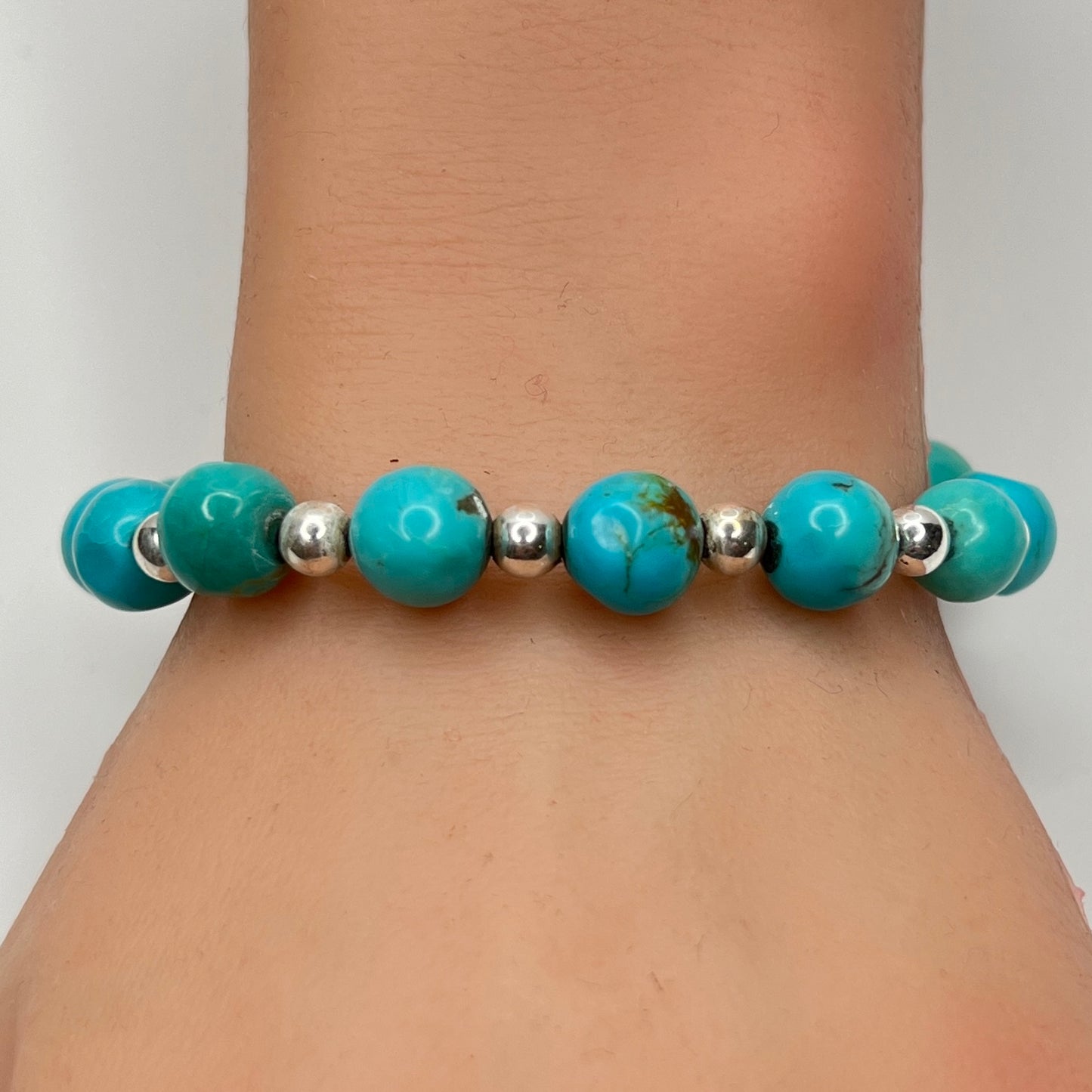 Turquoise and silver beaded bracelet worn on wrist – 9mm stones