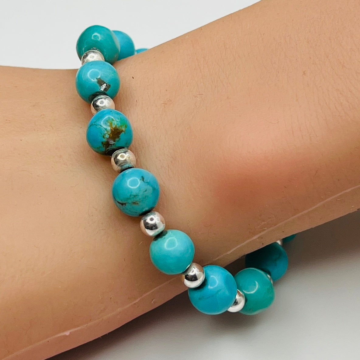 Turquoise and silver beaded bracelet worn on wrist – 9mm stones