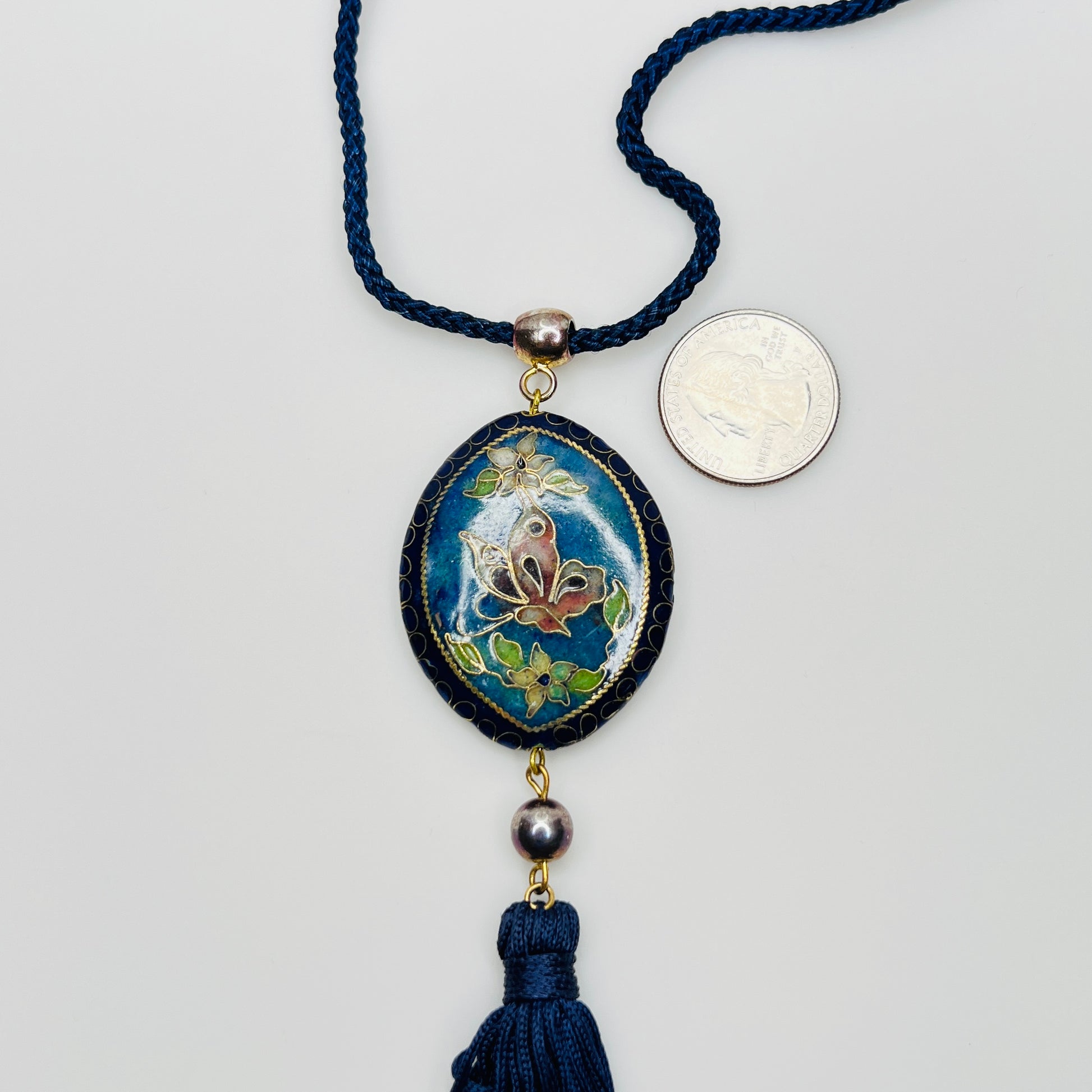 Close-up of butterfly cloisonné pendant with tassel drop