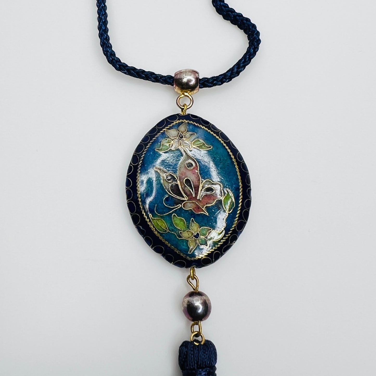 Close-up of butterfly cloisonné pendant with tassel drop