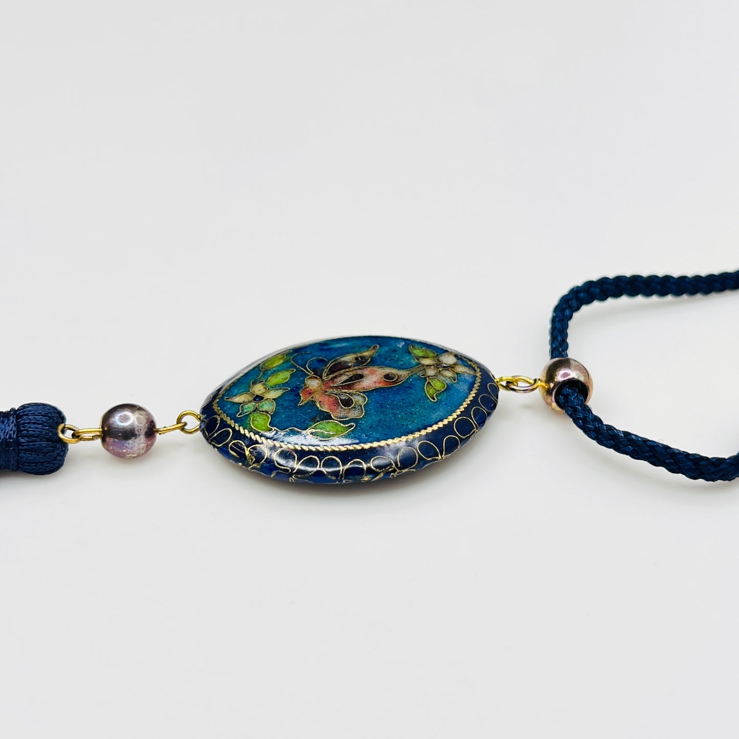 Close-up of butterfly cloisonné pendant with tassel drop
