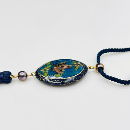 Close-up of butterfly cloisonné pendant with tassel drop