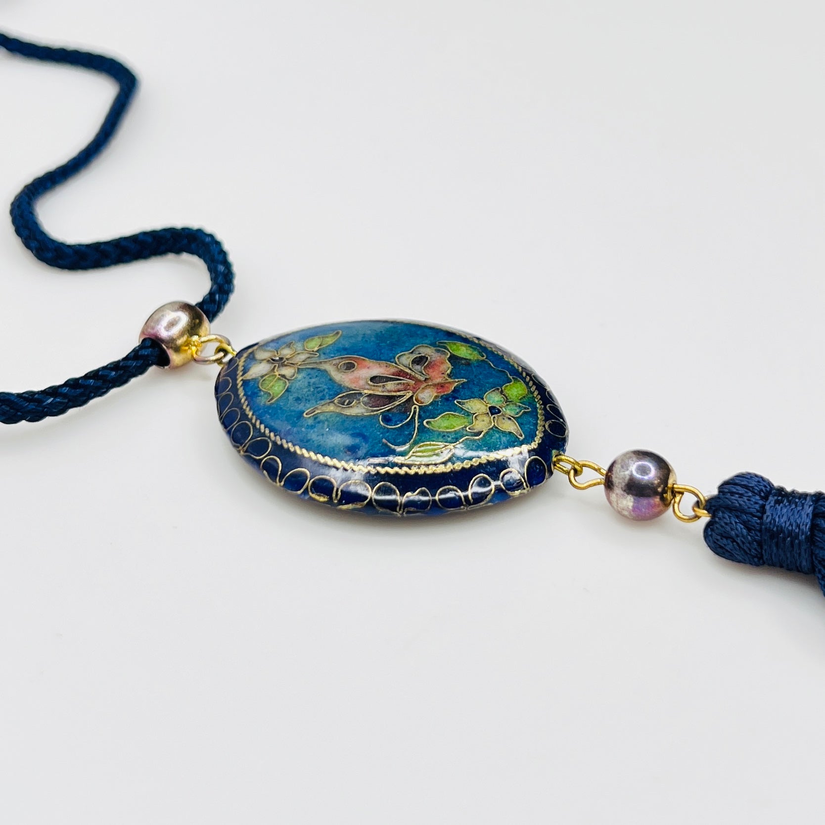 Close-up of butterfly cloisonné pendant with tassel drop
