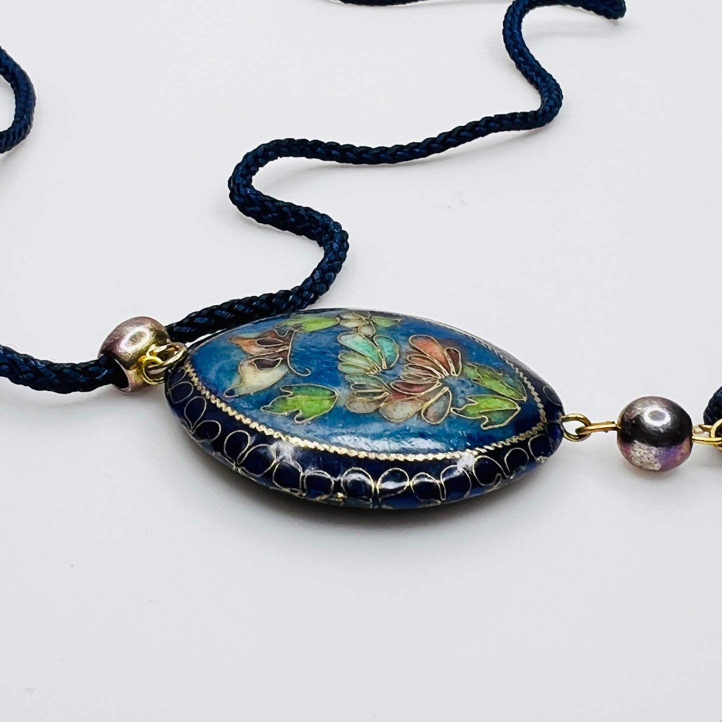 Close-up of butterfly cloisonné pendant with tassel drop