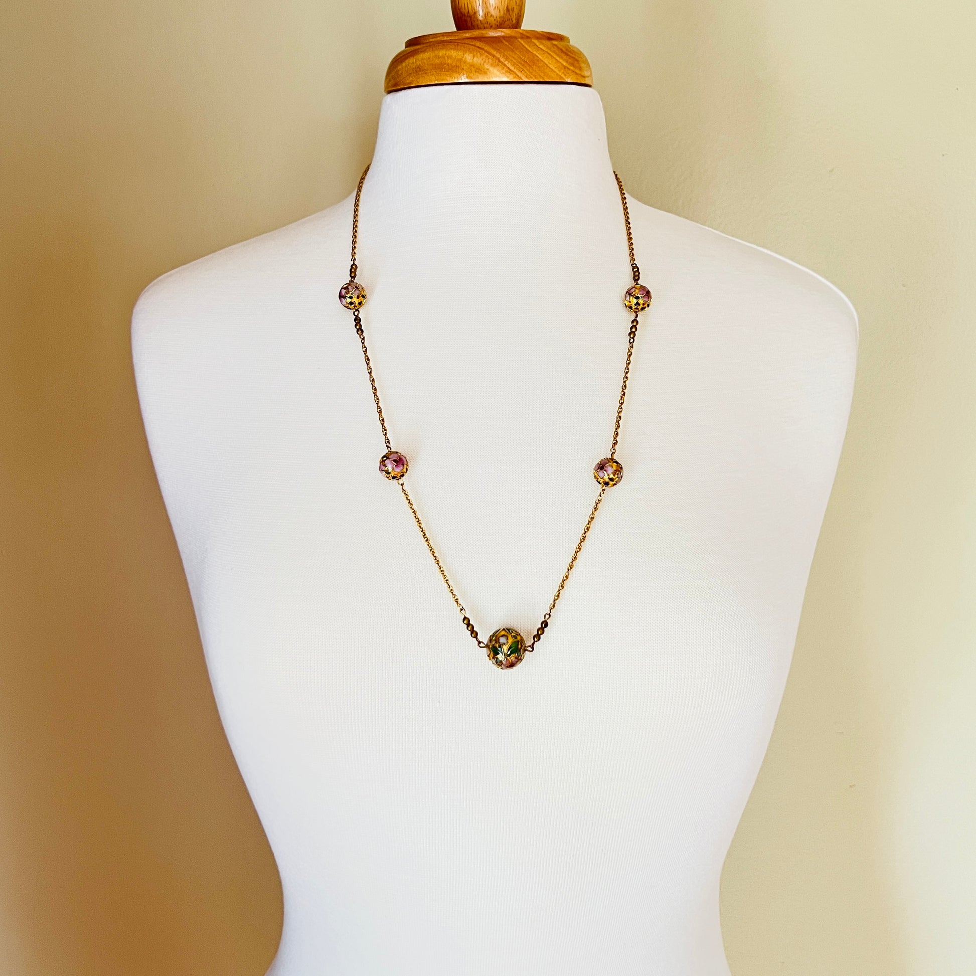 Close-up of necklace center bead with green and white floral detail