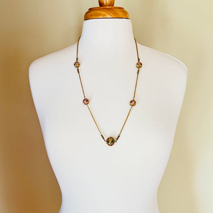 Close-up of necklace center bead with green and white floral detail