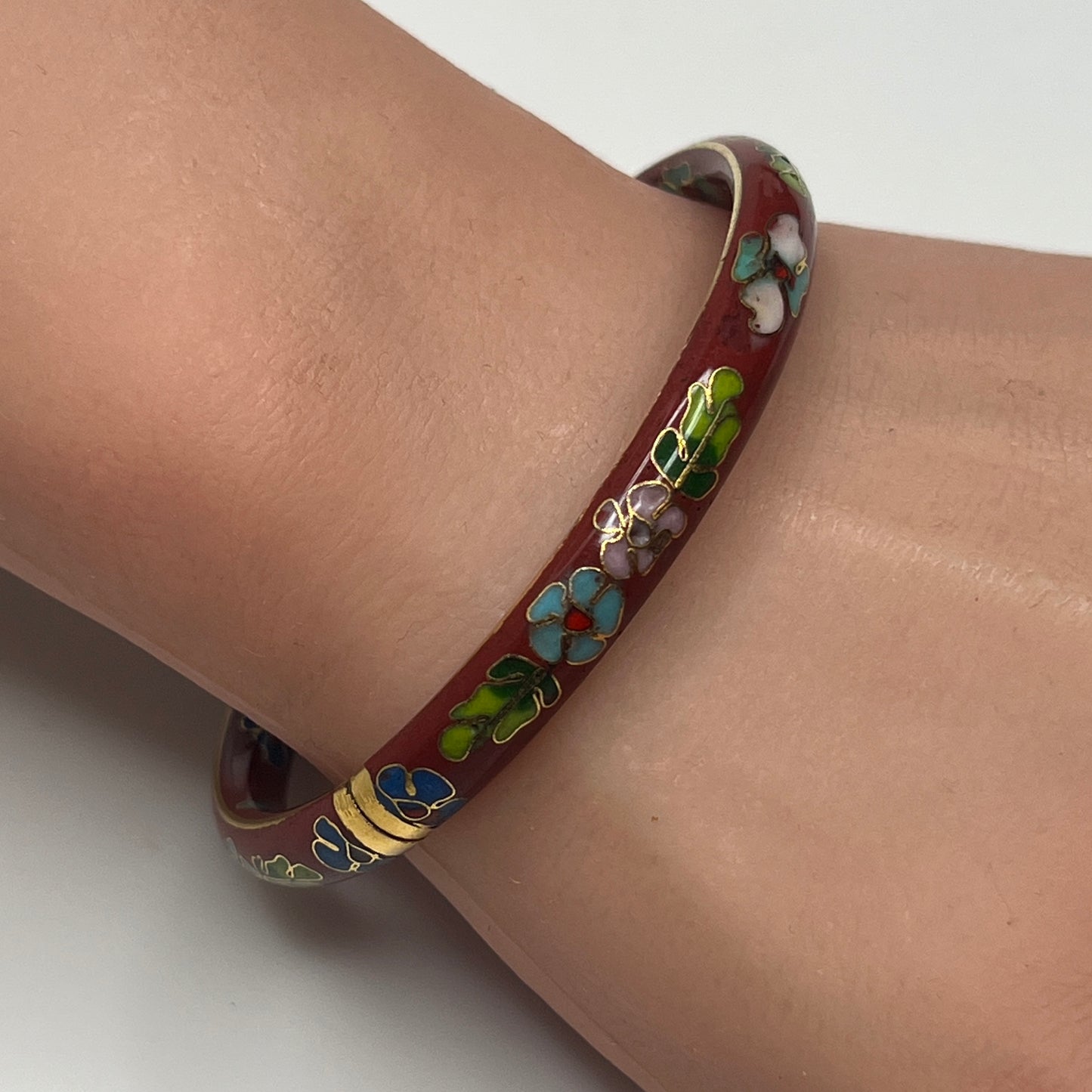 Side view of hinged cloisonné bracelet with gold detailing