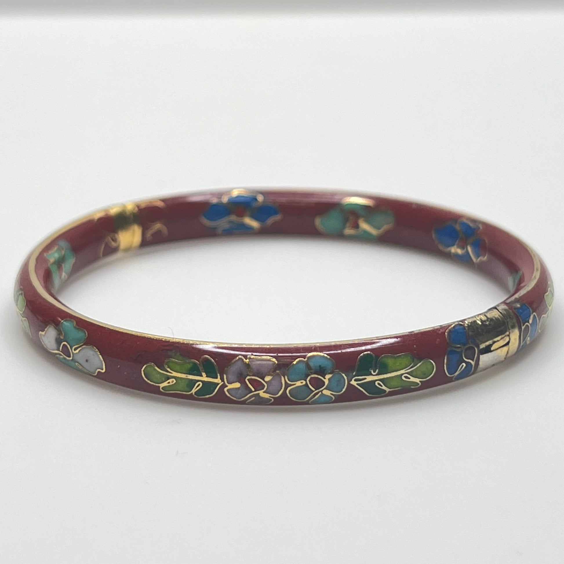 Close-up of enamel flower motifs on red background