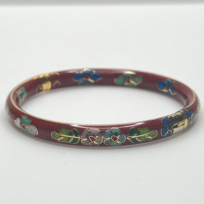 Close-up of enamel flower motifs on red background