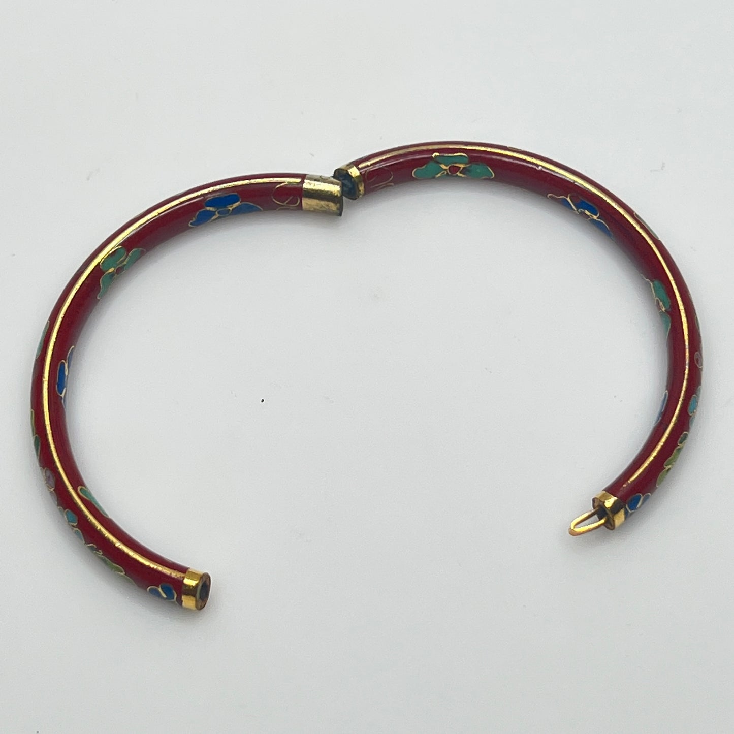 Close-up of enamel flower motifs on red background