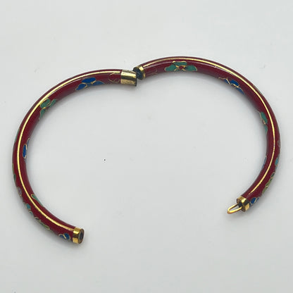 Close-up of enamel flower motifs on red background