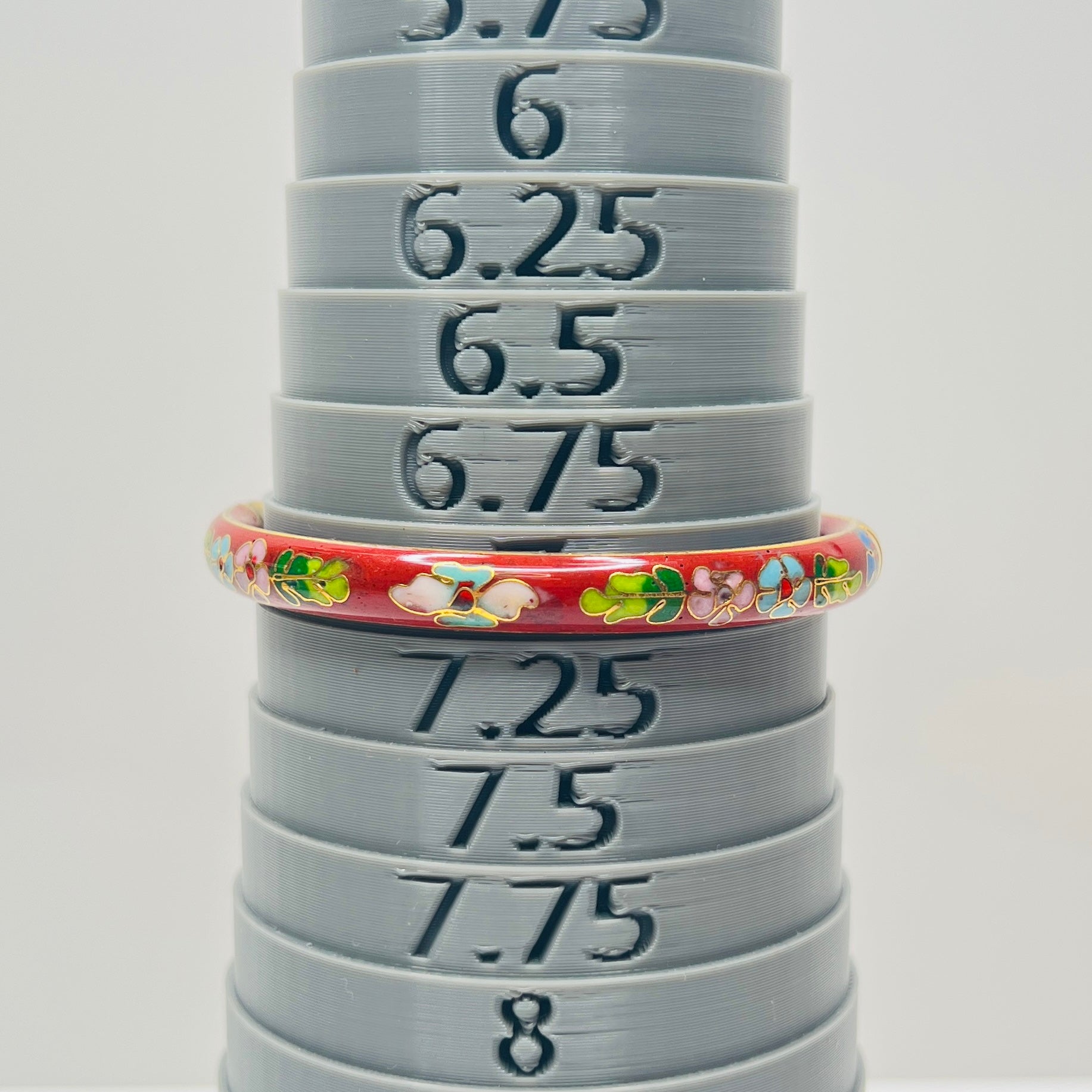 Close-up of enamel flower motifs on red background