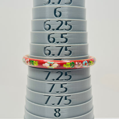 Close-up of enamel flower motifs on red background