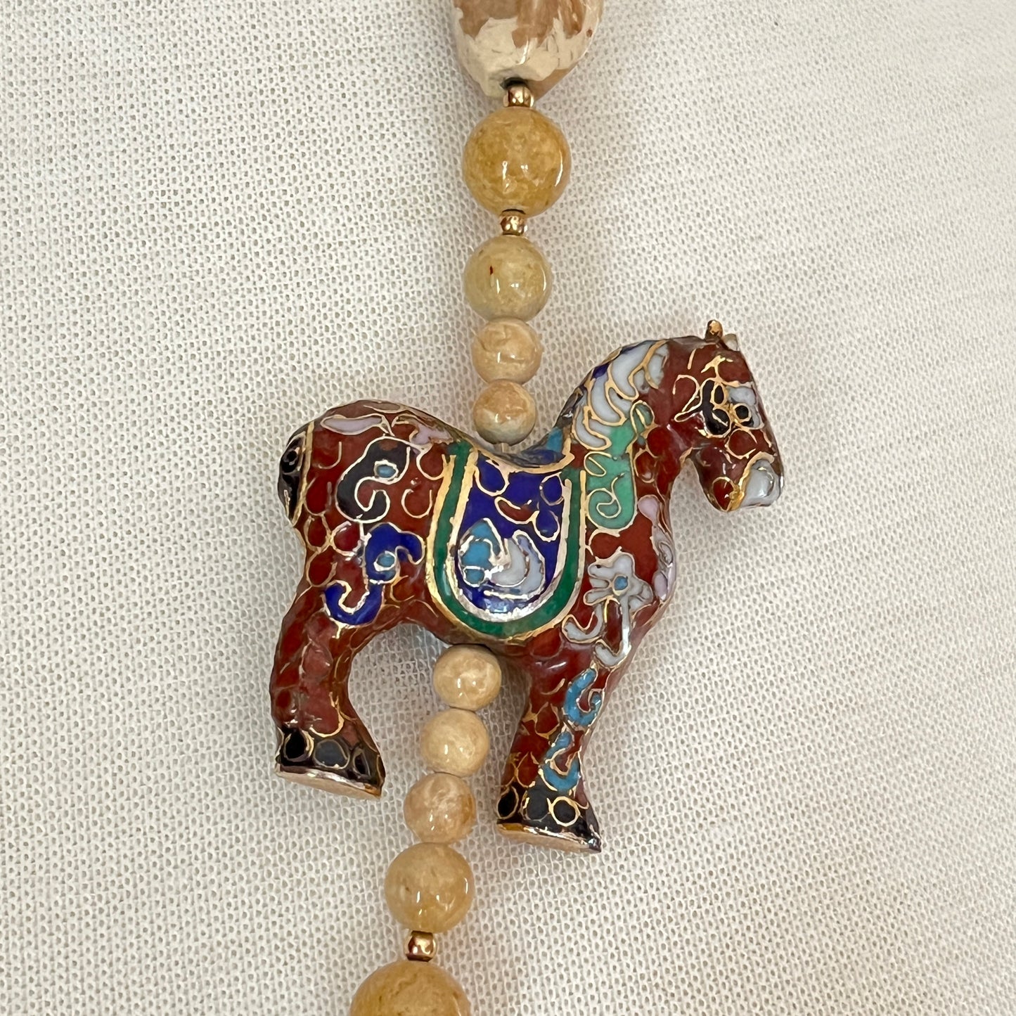 Detail of cloisonné horse pendant with multicolor enamel work