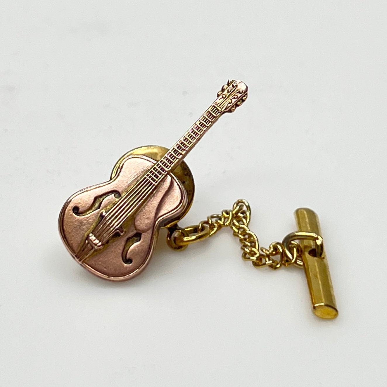 1960s copper guitar tie tack with gold tone chain and detailed fretwork