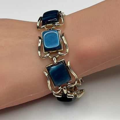 Coro blue lucite thermoset bracelet on wrist with sculptural gold-tone links
