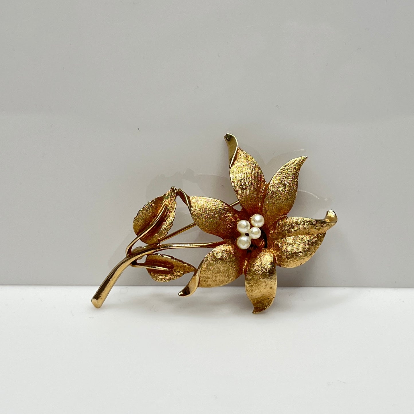 Vintage Coro gold-tone flower brooch with faux pearl center and textured petals