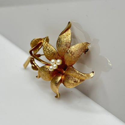 Vintage Coro gold-tone flower brooch with faux pearl center and textured petals