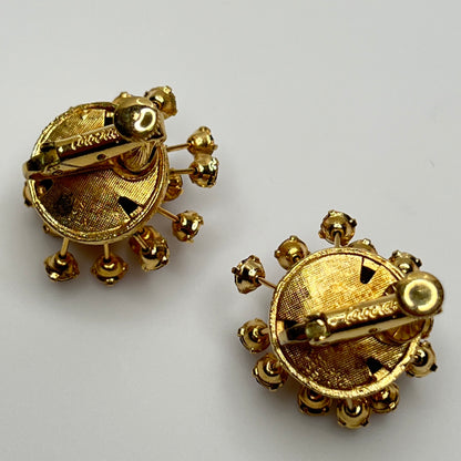 Matching Corocraft clip-on earrings with radiating rhinestone design in pink and plum tones