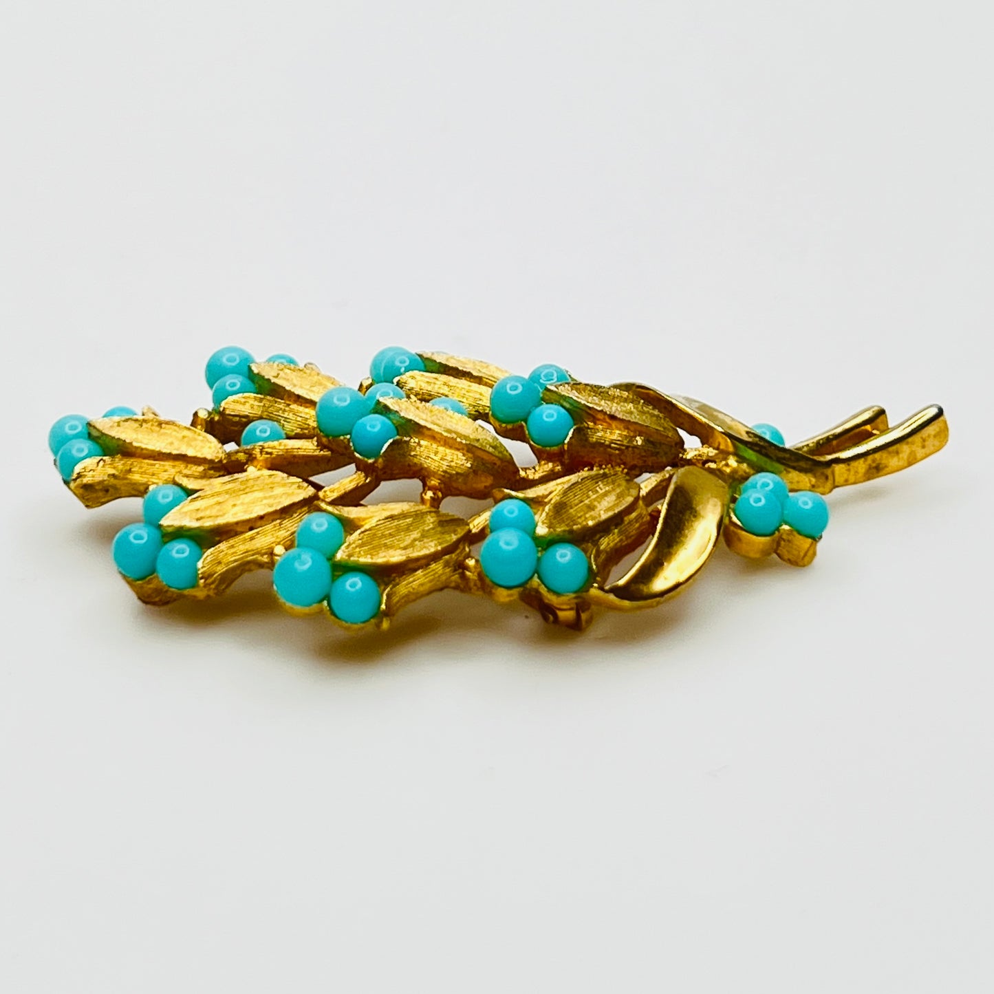 Gold tone floral brooch with faux turquoise beads