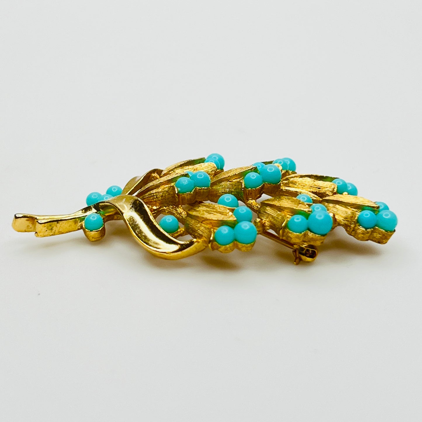 Gold tone floral brooch with faux turquoise beads