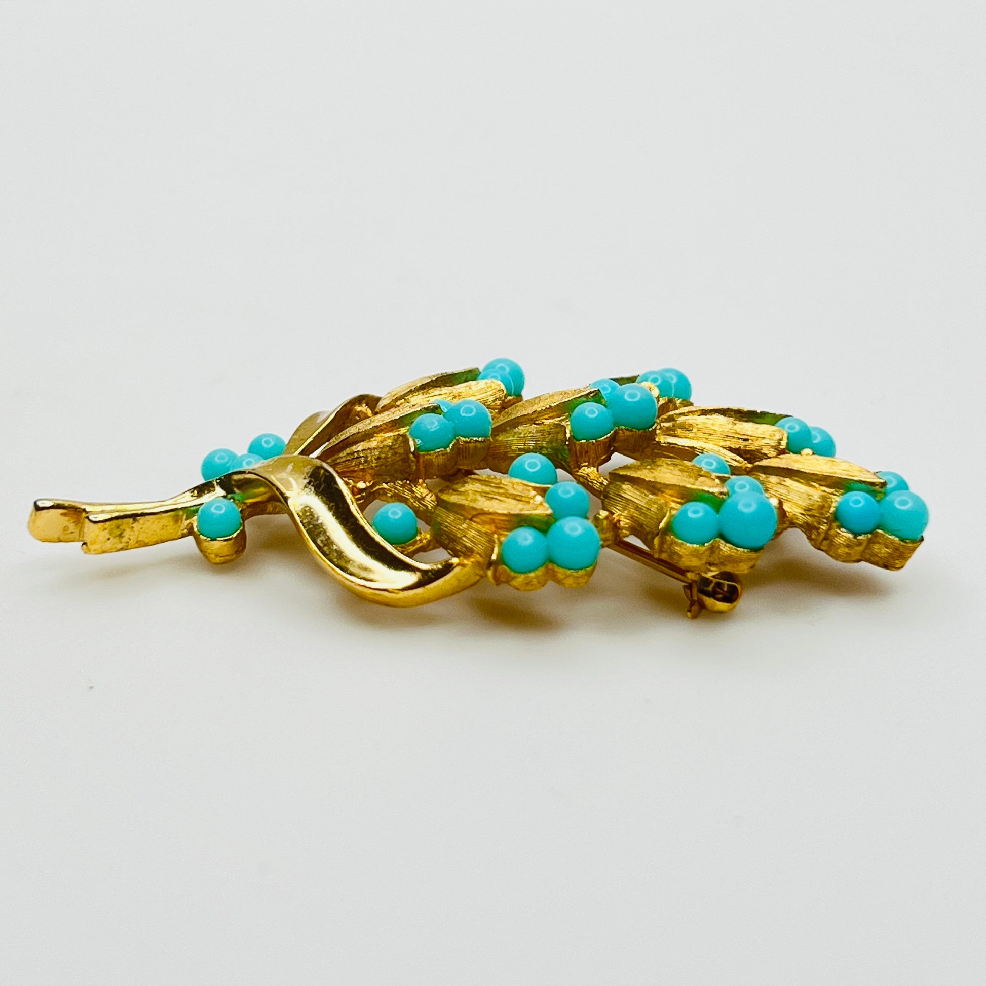 Gold tone floral brooch with faux turquoise beads
