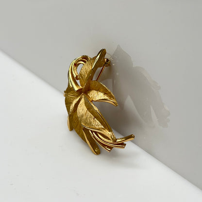 Crown Trifari brushed gold-tone leaf brooch with curling ribbon detail